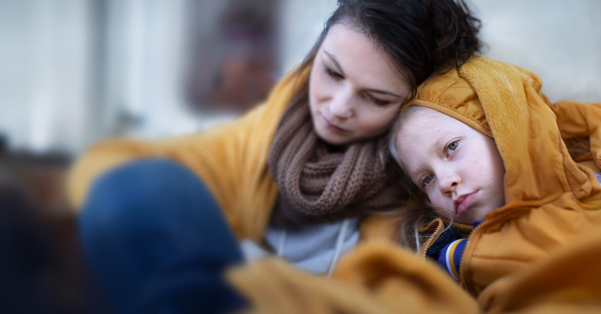 Armut ist weiblich: Die Folgen von Gender Care, Pay und Pension Gap Auf dem Bild ist eine Mutter und ihr Kind zu sehen. Beide wirken besorgt und haben warme Kleidung an, weil ihnen kalt ist.