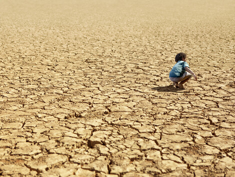 Child Playing on Dry Parched Desert Land